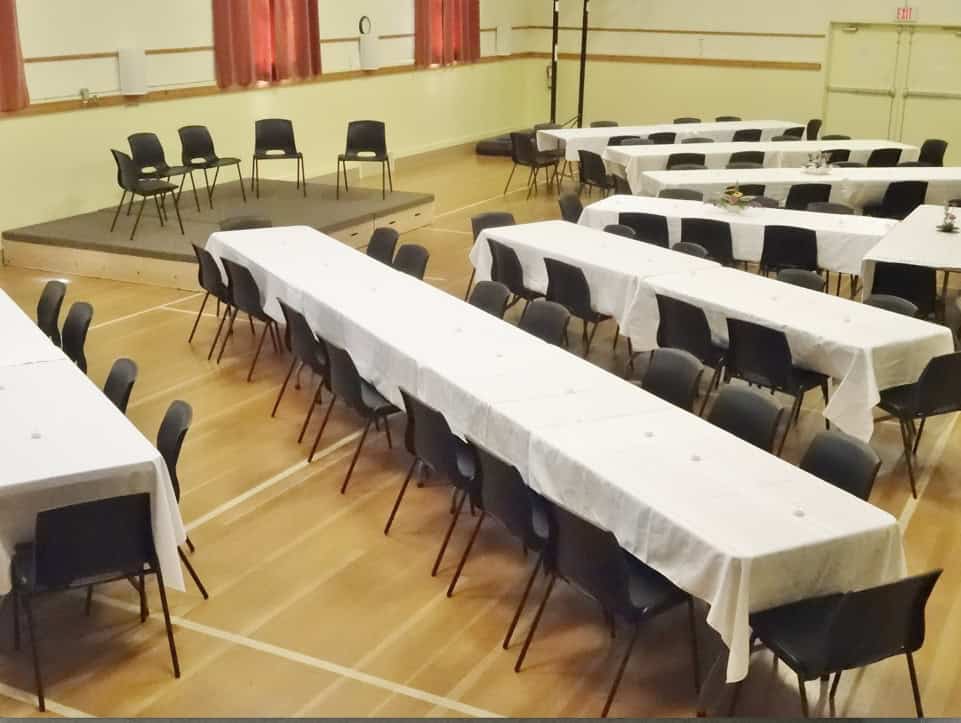 Community hall with long tables and chairs for events and gatherings.